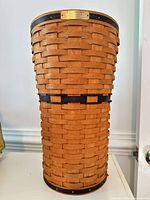 Full view of tall woven basket showing weave pattern and black accent
