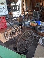 side view showing scrollwork wheels, shelves, rust