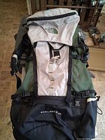Front view showing lid, front pocket, straps and logo