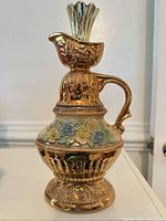 Front view of gold floral Jim Beam ceramic decanter with stopper