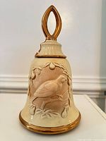 Full view of bell-shaped decanter with gold handle and trim