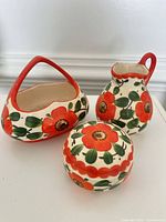 Front view of all three Coronet floral ceramic pieces