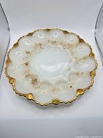 Top view of milk glass egg tray showing 12 wells and gold trim