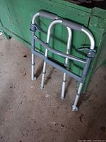 Full view of folded walker leaning against green surface
