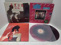 Three LP sleeves displayed, showing Sakamoto, group, female singer, plus maroon vinyl disc