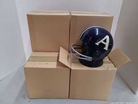 Four cardboard boxes with one helmet radio displayed on top