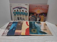 Front view showing all seven record jackets, two upright and five stacked