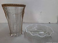 Clear ribbed glass vase beside white hobnail milk glass divided dish