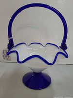 Front view showing handle, ruffled edge, pedestal base