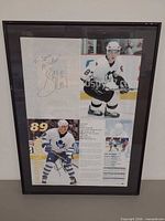 Full view of framed magazine page showing both player images and signatures