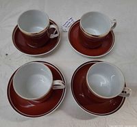 Overhead view of four cups on saucers showing colors and condition