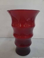 Front view of red burgundy glass vase showing tiered design