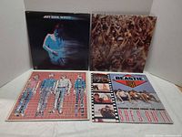 Four album covers displayed: Jeff Beck "Wired", Crosby & Nash "Live", Talking Heads "More Songs About Buildings and Food", Beastie Boys "She's On It"