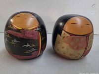 Front view of both kokeshi dolls side by side