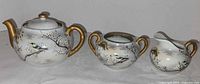 Full view of teapot, sugar bowl and creamer, showing pattern and gilding