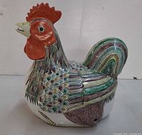 Left side view of porcelain rooster tureen showing hand-painted feather details