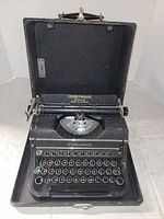 Typewriter seated in open carrying case