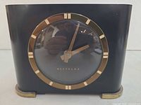 Front view of Westclox clock showing dial, hands, brass ring, and case