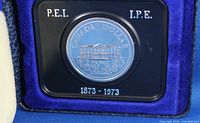 Reverse of coin showing Province House design and inscriptions within display case