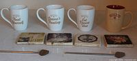 Front view of four Baileys mugs, four coasters and two stir sticks