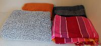 Four folded throws showing variety of colors and textures