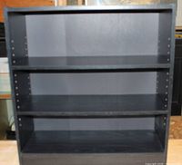Front view showing entire black bookcase with three shelf levels