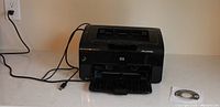Front angled view of printer with USB cable and CD