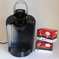 Front view of Keurig brewer beside two Twinings Chai boxes