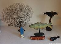 Overall view of coral sea fan, fish sculpture, crow figurine, Fiji boat carving and whale bottle opener