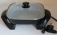 Overall view of Oster electric frying skillet with lid and temperature control probe