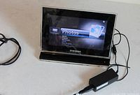 Front view of Samsung digital photo frame powered on with adapter connected