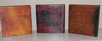 front view of three square abstract paintings