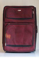 Front view showing burgundy suitcase with two external zip compartments