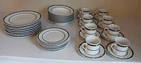 Stacks of dinner plates, salad plates and arranged cups with saucers
