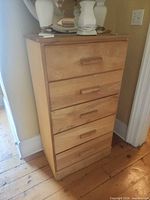 Front view of light wood 5-drawer dresser