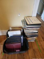 Two plastic baskets and stack of classical LP records beside wall