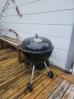 Full view of Weber kettle grill on tripod stand with wheels