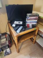 Overall view showing monitor, Blu-Ray player, remotes, and stack of VHS tapes