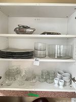Cabinet shelves with trays, charger plates, glass bowls, tumblers, vase and egg cups