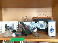 Shelf with assorted bird carvings, vases, print, plaques and sign