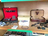 Shelf view showing jewelry boxes, assorted tie clips, cufflinks, trinket boxes, and other small jewelry pieces