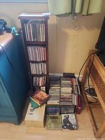 CD tower shelf filled with CDs, additional stacks of CDs on floor