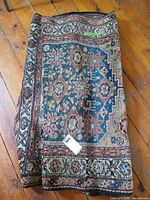 Folded Persian style rug showing overall pattern and color palette