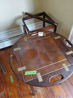 Top view of one tray table showing hinged tray sides, brass hinges, hand slots