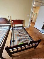 Full view of single bed frame showing headboard, footboard, and metal spring base