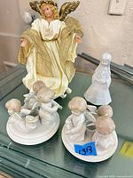 Full view of angel tree topper, pair of candlestick holders, and bell