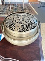 Top view showing pierced floral lid design and overall round shape