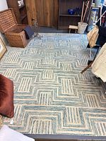 Full view of off-white and teal zigzag wool area rug on floor