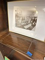 Front view of framed photograph standing on shelf, tray positioned below