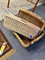 Three nested wicker baskets with one lidded hamper visible